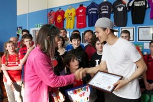 Hoang Nguyen, Vietnamese refugee and player and coach at Brighton Table Tennis Club receives the UK's first Club of Sanctuary award from Jenny Lansdell, Chair of Sanctuary on Sea. The award was made for the club's work with young refugees.