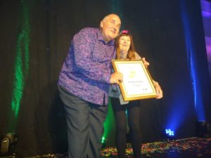 Golden Handbags founder James Ledward presents a special award to "straight friend" Elaine Evans from Hove