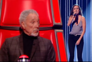 Tom Jones listens as Clara Hurtado sings on The Voice on ITV