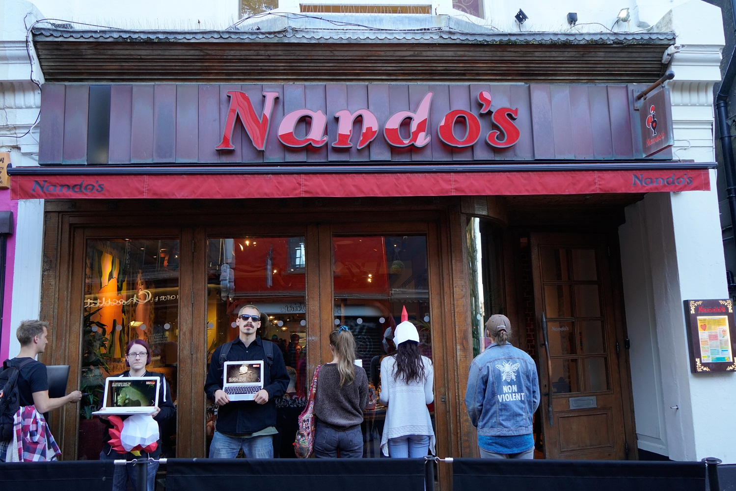 Vegan protesters swap pig masks for chicken masks as they target Nando’s