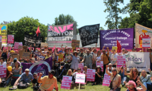 A rally of people holding UCU banners and signs to "Save the Unviersity"