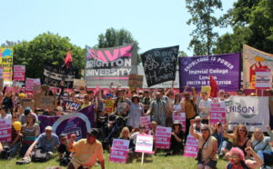 A rally of people holding UCU banners and signs to "Save the Unviersity"