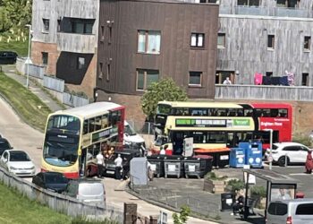 People roll car to let buses through tight corner