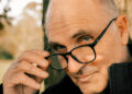 Man's face with hand removing his glasses