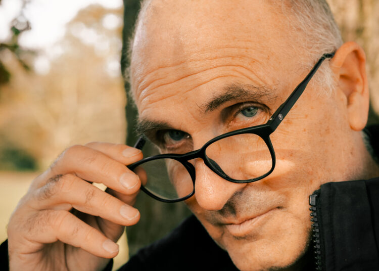 Man's face with hand removing his glasses